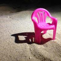 miniatuur roze stoelen op het strandzand foto