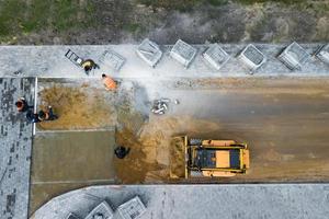 het leggen van straatstenen op het voorbereide betonoppervlak. reparatie van het voetpad in de stad. stedelijk gemeentelijk werk foto