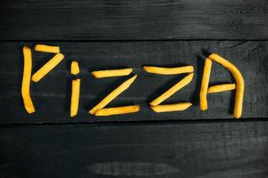 de inscriptie pizza gemaakt van frietjes foto