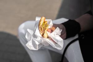gebeten hamburger in een close-up van de mensenhand. foto