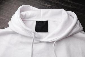 leeg zwart label op wit sweatshirt voor logo, maat en info. foto
