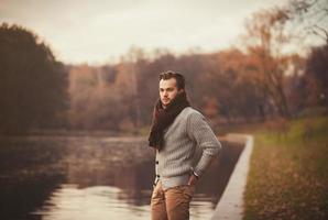 jonge man die zich voordeed in het herfstpark foto