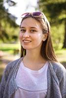 portret van een meisje dat lacht naar de camera in de natuur foto