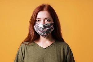 jonge vrouw die een zelfgemaakt stoffen gezichtsmasker of een gemeenschapsmasker draagt foto