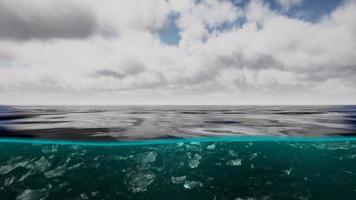 gesplitst uitzicht over en onder water in de Caribische zee met wolken foto