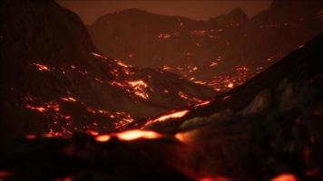 roodoranje levendige gesmolten lava die op grijs lavaveld en glanzend rotsachtig land stroomt foto