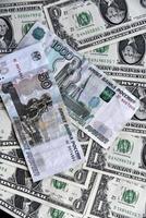 roebels en munten op de achtergrond van dollarbiljetten foto