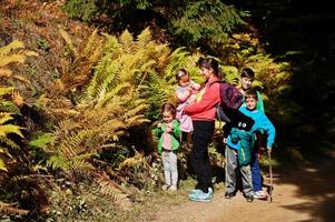 moeder met vier kinderen in het bos van de bergen in de buurt van de varen. familie reizen en wandelen met kinderen. foto