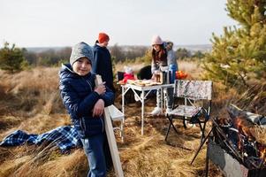 familie barbecueën op een terras in het dennenbos. bbq-dag met grill. foto