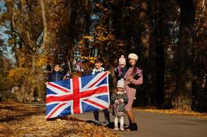 nationale feestdag van het verenigd koninkrijk. familie met britse vlaggen in herfst park. britse vieren uk. moeder met vier kinderen. foto