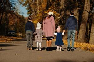 achterkant van moeder met vier kinderen op herfstpark. foto