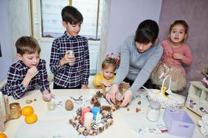 moeder met vier kinderen maakt een krans voor kerstavond en knutseldecoratie. nieuwjaarsviering. foto