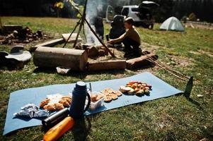 familie vreugdevuur in de bergen. herfstwandeling en kampweer. opwarmen en koken in de buurt van vlam samen. foto