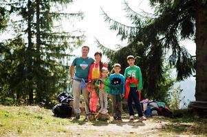 groot gezin met vier kinderen die in de bergen rusten. reizen en wandelen met kinderen. foto