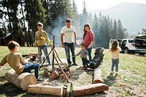 familie vreugdevuur in mountain.four kinderen kamperen. marshmallows van de barbecue. herfstwandeling en kampweer. opwarmen en koken in de buurt van vlam samen. foto