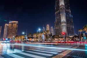 burj khalifa wolkenkrabber 's nachts in dubai. druk kruispunt met auto's en voetgangers in het midden van Dubai. foto