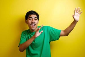 Aziatische man in groen t-shirt lacht en danst vrolijk foto