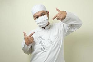 dikke Aziatische moslimmannen die maskers dragen met zelfverzekerde gebaren foto