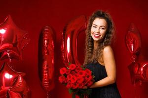 jonge volwassen vrouw op de achtergrond van rode ballonnen foto