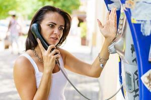 positieve brunette vrouw met telefoonhoorn oproepen via briefpapier foto