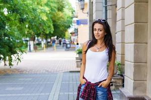 buitenshuis levensstijl mode portret van tevreden jonge vrouw buiten zitten. foto