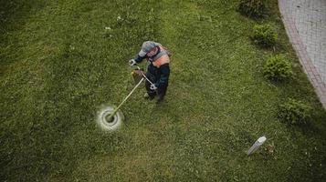 de grasmaaier man maait het gazon het uitzicht vanaf de top foto