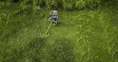 de grasmaaier man maait het gazon het uitzicht vanaf de top foto