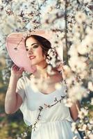 portret van een jonge vrouw in de bloemrijke tuin in de lente foto