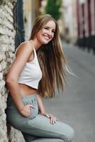 lachend blond meisje met steil haar op stedelijke achtergrond foto