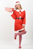 blonde vrouw in santa claus kleding lachend met geschenkdozen. foto