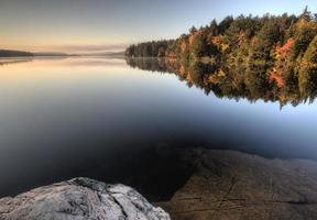 meer in de reflectie van de herfstzonsopgang foto