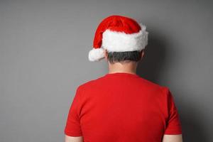 achteraanzicht van man met kerstmuts en rood t-shirt foto