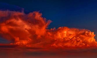 licht oranje zonsondergang hemel met wat wolken oppervlakte abstracte stroom donder wolken in de lucht bij zonsondergang. foto