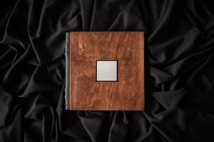 houten boek met een naambordje op een zwarte stoffen ondergrond. foto
