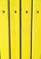 planken beschilderd met gele verf houten hek met metalen klinknagels, muur, verticale achtergrond foto