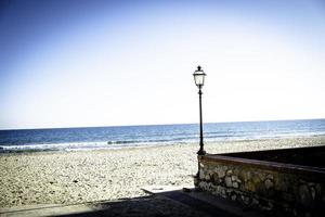 een lantaarnpaal op het zandstrand van laigueglia, in het westen van ligurië in de provincie savona foto