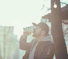 man in een leren jas die koffie drinkt foto