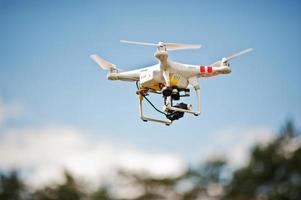 drone quad copter met digitale camera met hoge resolutie die in de blauwe lucht vliegt foto