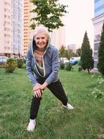 senior vrouw die sportoefeningen in het park doet. gezond levensstijlconcept foto