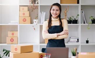 portret van aziatische jonge vrouw mkb werkend met een doos thuis de werkplek. start-up kleine ondernemer, kleine ondernemer mkb of freelance bedrijf online en leveringsconcept. foto