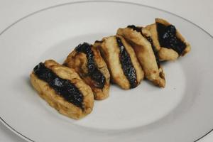 gebakken tofu of tahu met petissaus in witte plaatachtergrond, Javaanse traditionele Indonesische snack foto