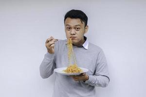 jonge aziatische man geniet van noedels. lunchconcept eten. foto