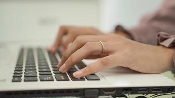 Aziatische vrouw typt op haar laptop foto