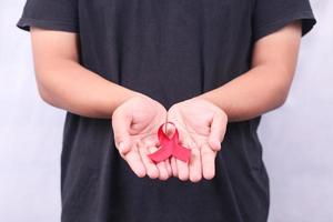 aids-symbool met rood lint in de hand geïsoleerd op een witte achtergrond foto