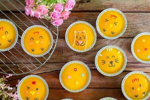 close-up minimale oranje cake met botercrème in folie beker op houten tafel. heerlijke bakkerij in koffie- en theetijden foto