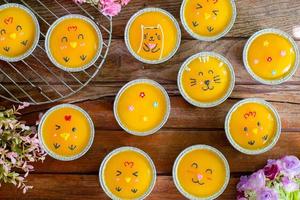 close-up minimale oranje cake met botercrème in folie beker op houten tafel. heerlijke bakkerij in koffie- en theetijden foto