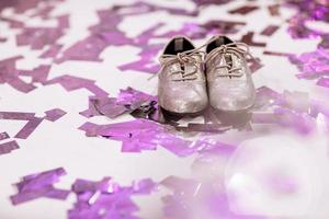 stijlvolle babyschoenen op witte achtergrond met kleurrijke confetti een copyspace. plaats voor inschrijving. foto