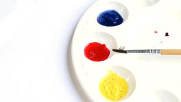 primaire aquarel met rood blauw geel op kleurplaat en penseel foto