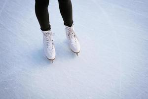 meisje in witte schaatsen op ijs. foto