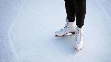 meisje in witte schaatsen op ijs. foto